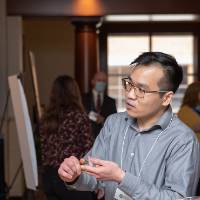 James Nguyen discussing his poster with Assistant Director of The Graduate School, Trista Bergerud.